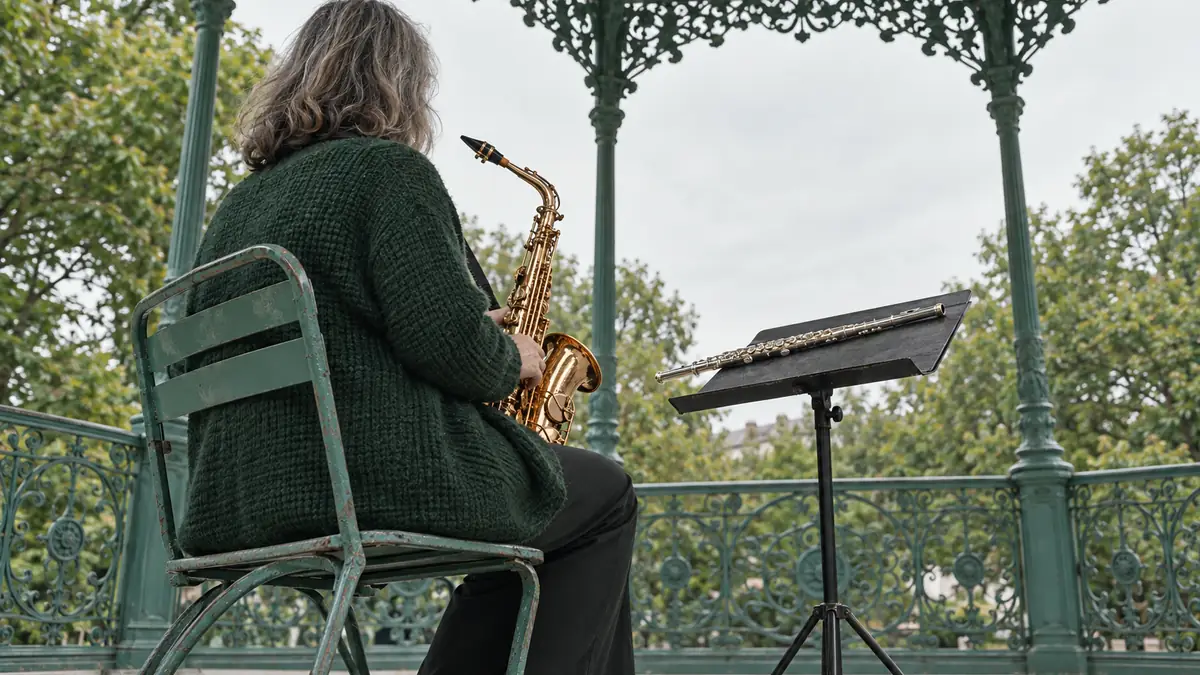 Pupitre de kiosque à musique, une partition d'harmonie ouverte et un bec de saxophone posé dessus